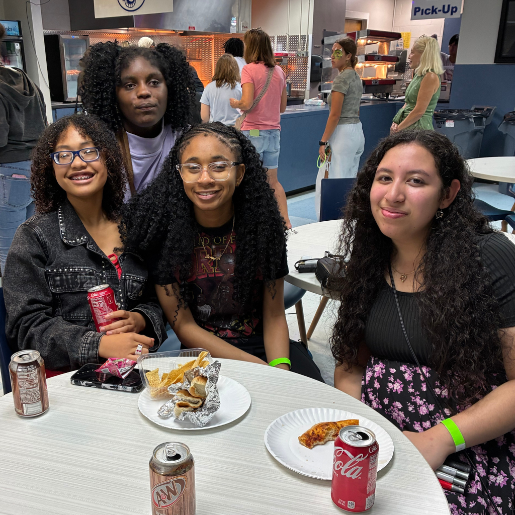 Four students smile with their food.