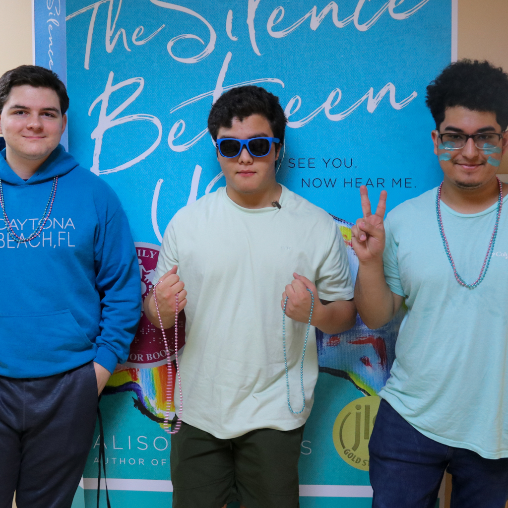 Three students dressed in blue and gray.