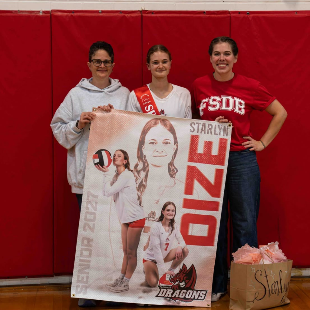 Senior smiles with her mom inside the gym.