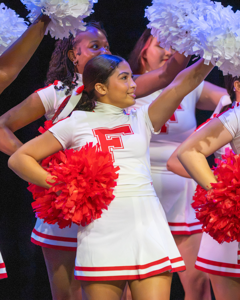 A cheerleader dances on stage in Kirk. 