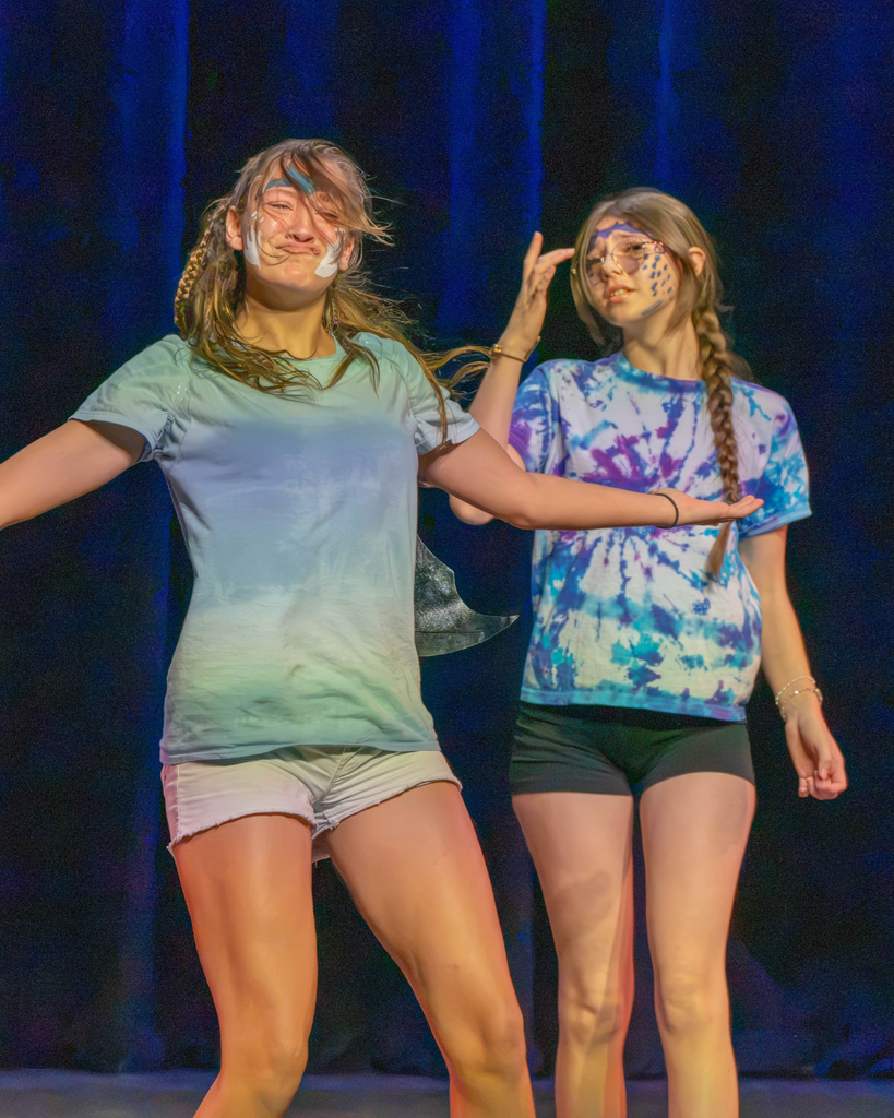 Two students dressed in tie dye perform on stage in Kirk. 