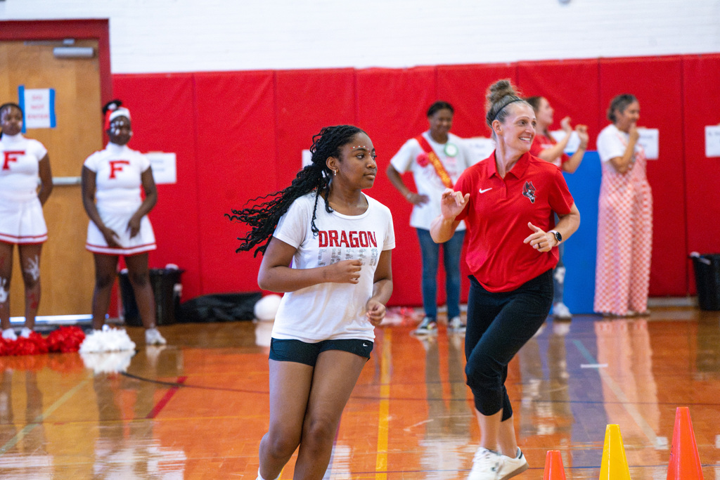 Student and Athletic Director runs during a game inside Settles Gym during the Pep Rally. 