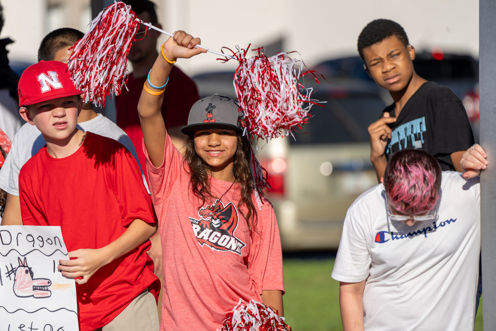 Student waves her pom poms waiting for the parade to start. 