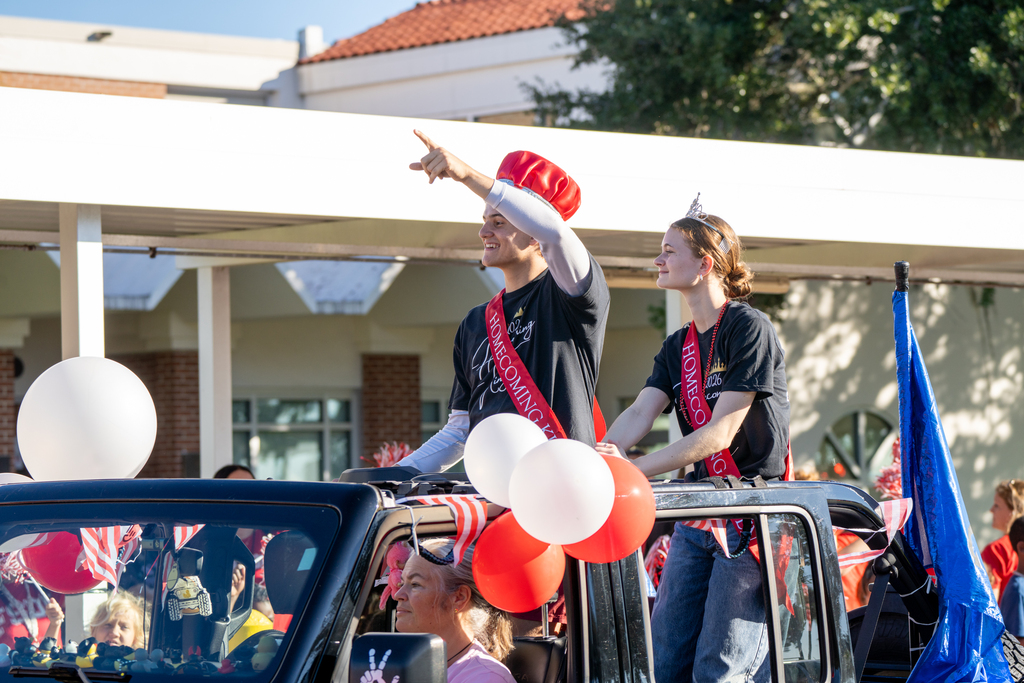 Homecoming King and Queen waves inside a jeep during the parade. 