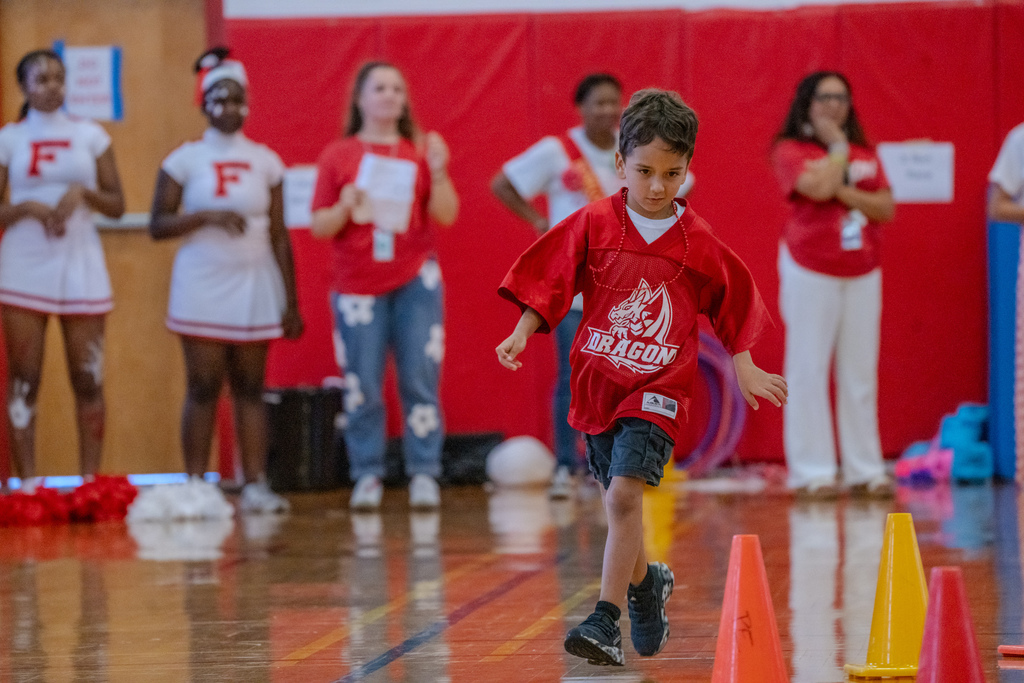 Student runs inside the gym during a pep rally game. 