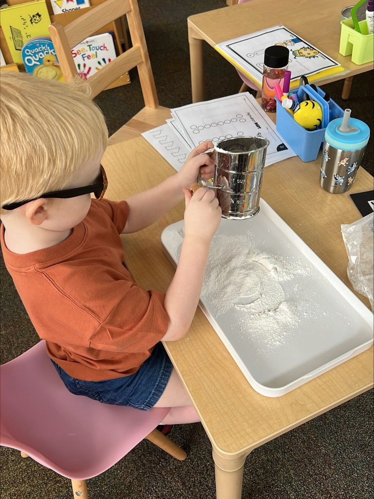 Jack is sifting flour onto a white board. 