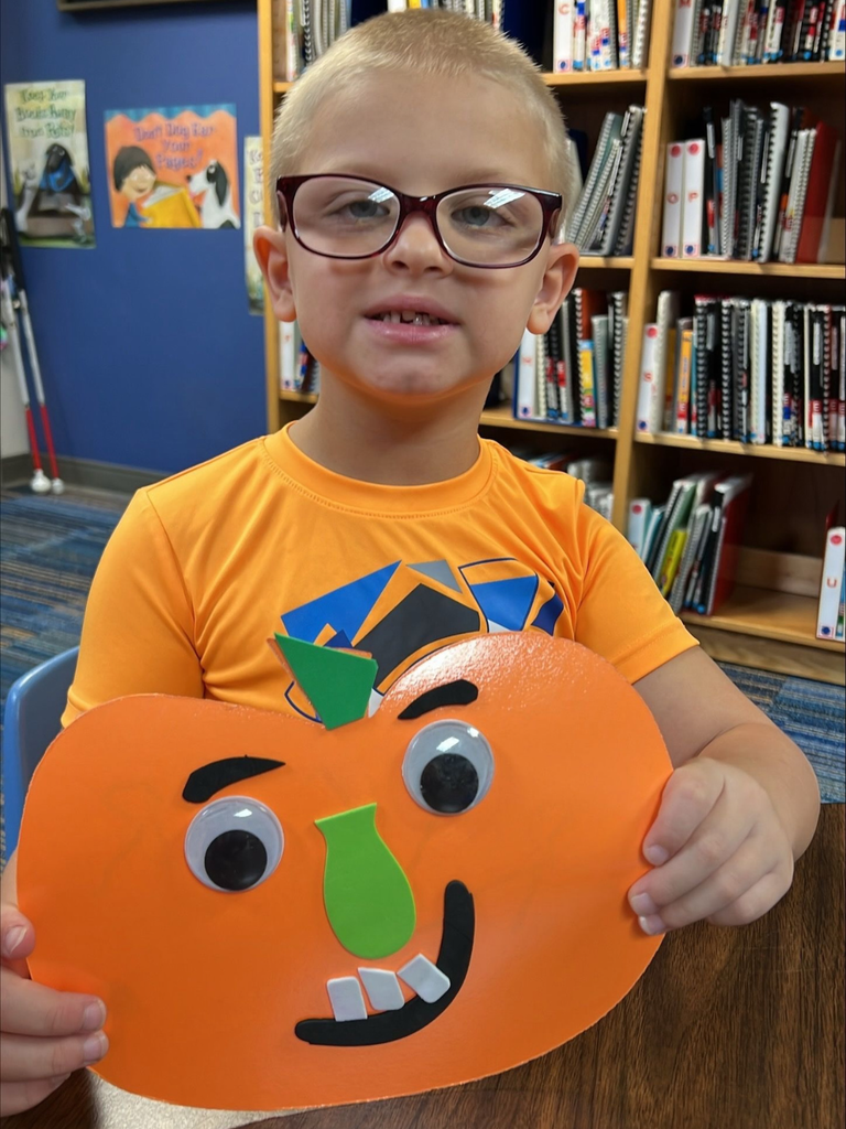 Ryker smiles with his pumpkin he created. 