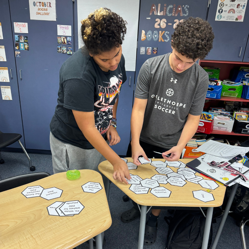 Two students work together to match cards inside a classroom.