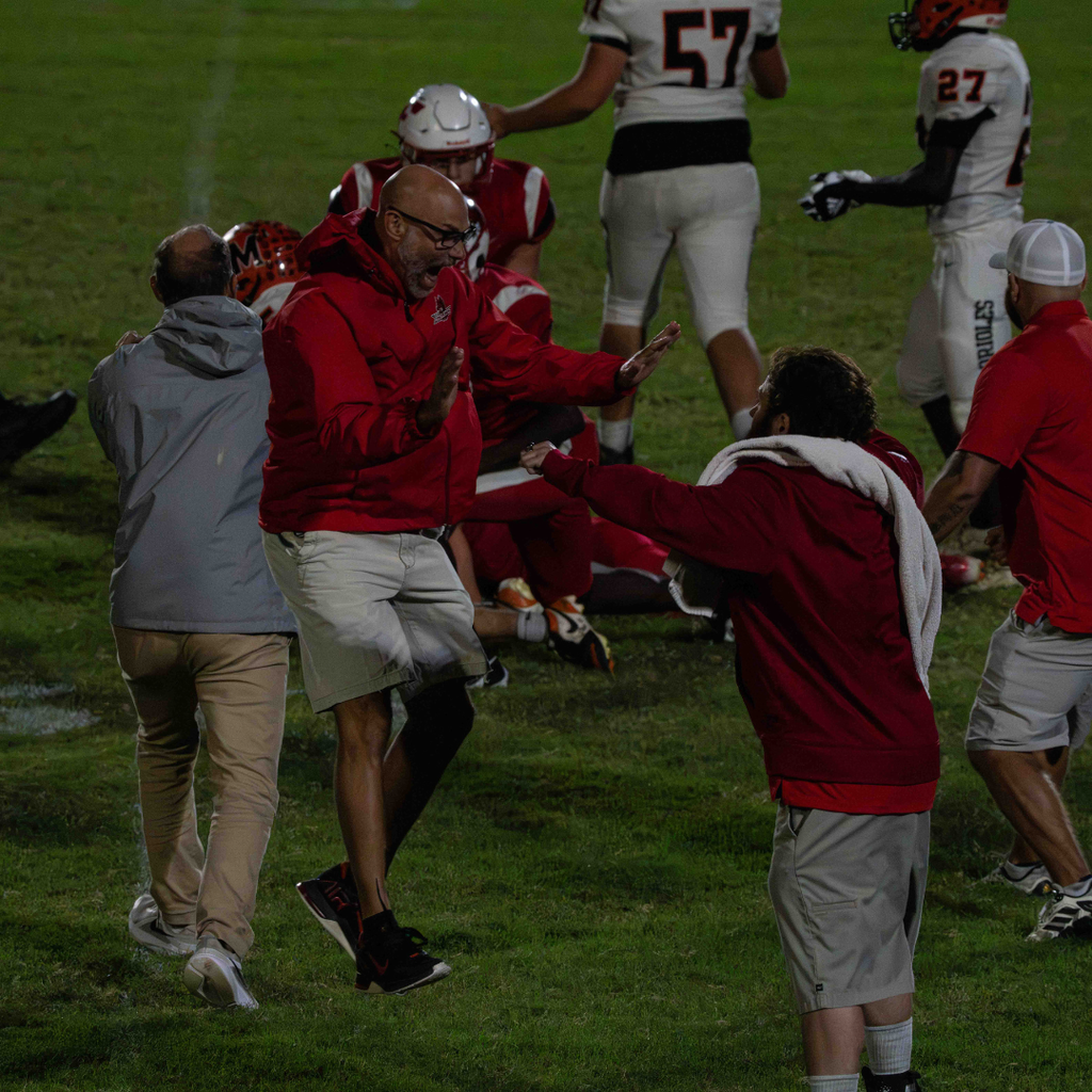 Two coaches excitedly jumps and high five each other when find out FSDB won. 