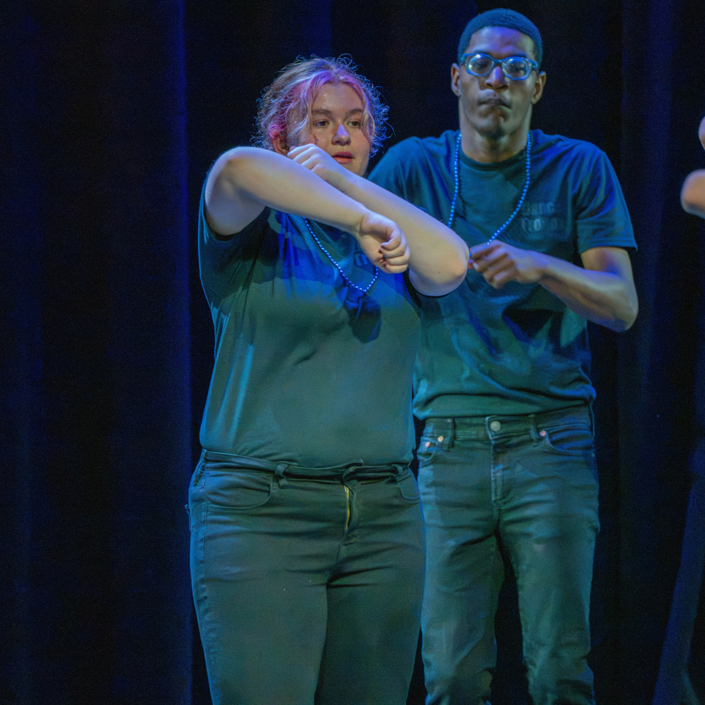 A dance troupe performer dances on stage. 