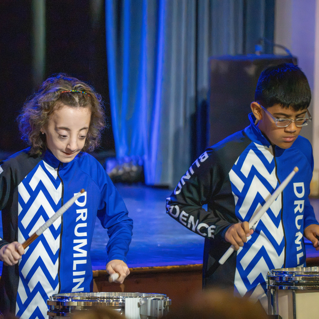 Two students dressed in "Drumline" uniform plays the drums for the audience in Kirk.