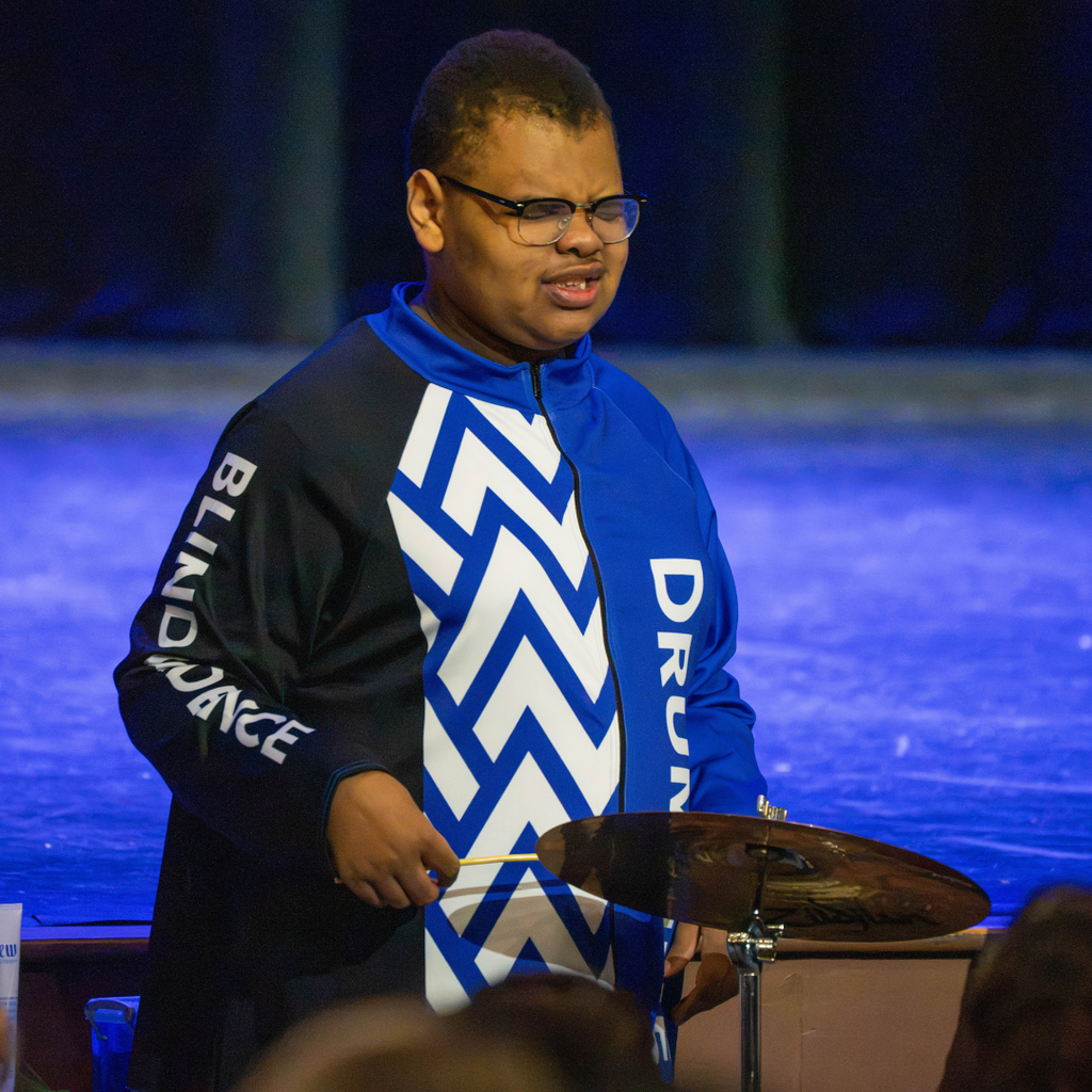 A student plays the drums for the audience in Kirk.