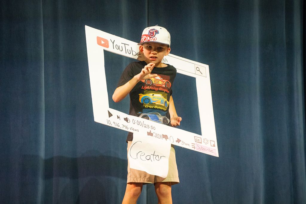 A boy wear a "Youtube" sign and the word "Creator" below.