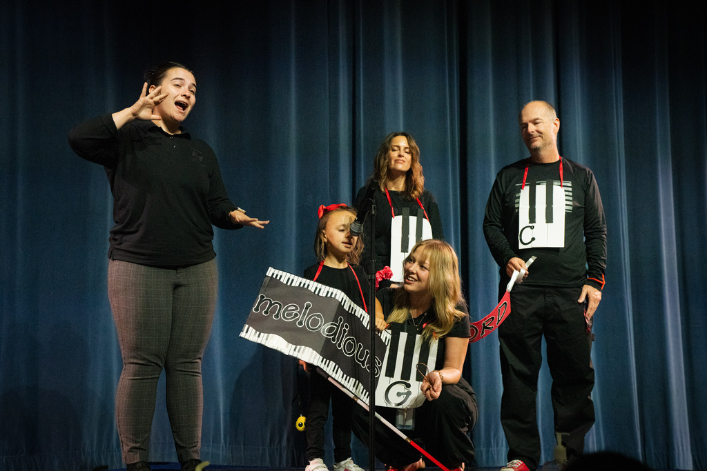 Three staff and one student dressed like a keyboard with the word "melodious" over the girls chest.