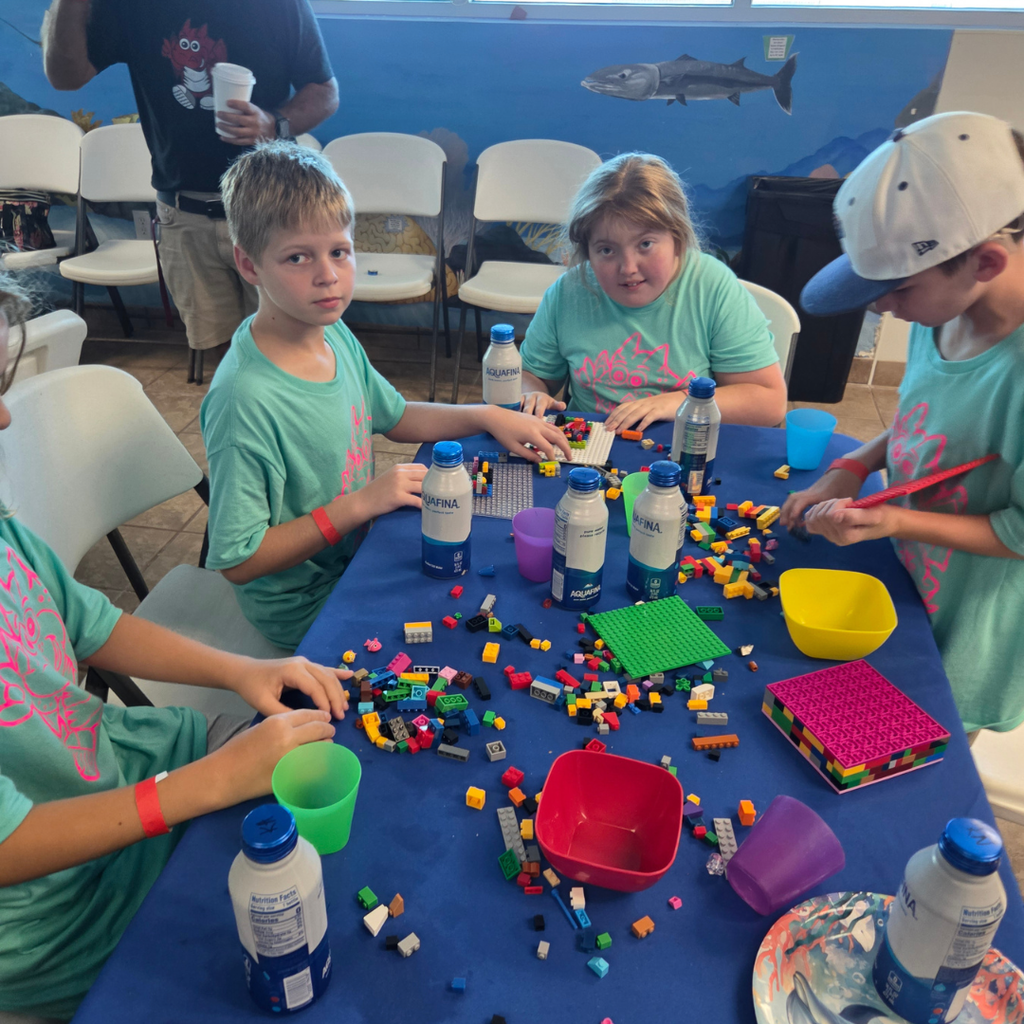 Group of students working on legos inside.