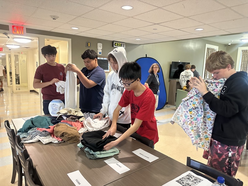 Boys learning to fold their clothes.