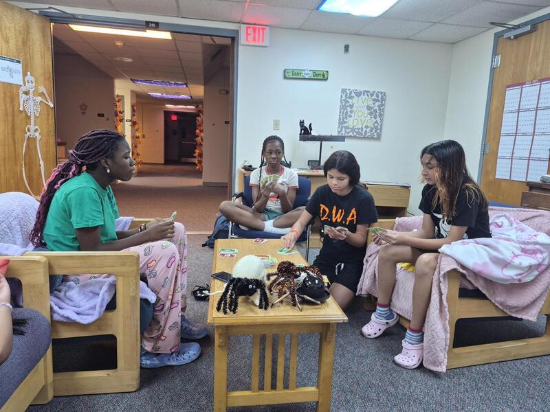 Four girls playing Uno in the dorm.