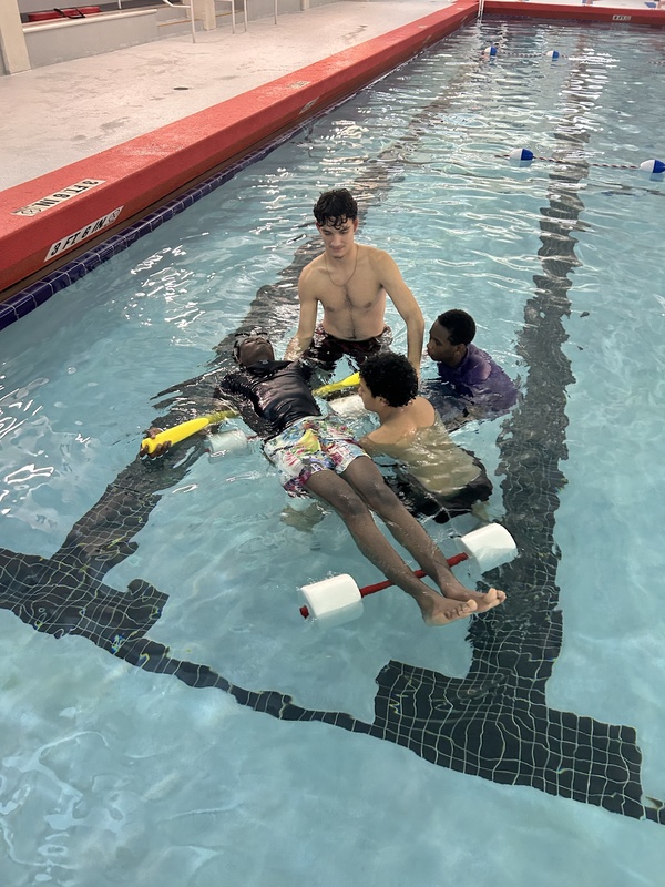 Boys in pool learning to swim