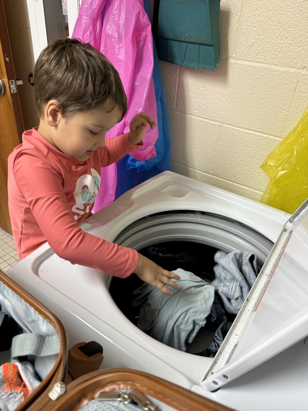Teaching Samuel how to wash his clothes.