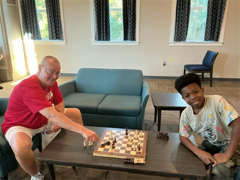 Jamie, Residential Instructor, playing chess with Prince.