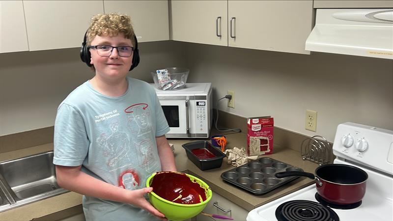 Student making cupcakes in the kitchen.