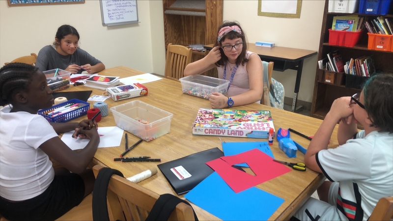 DES girls at at table with games, and arts and crafts.