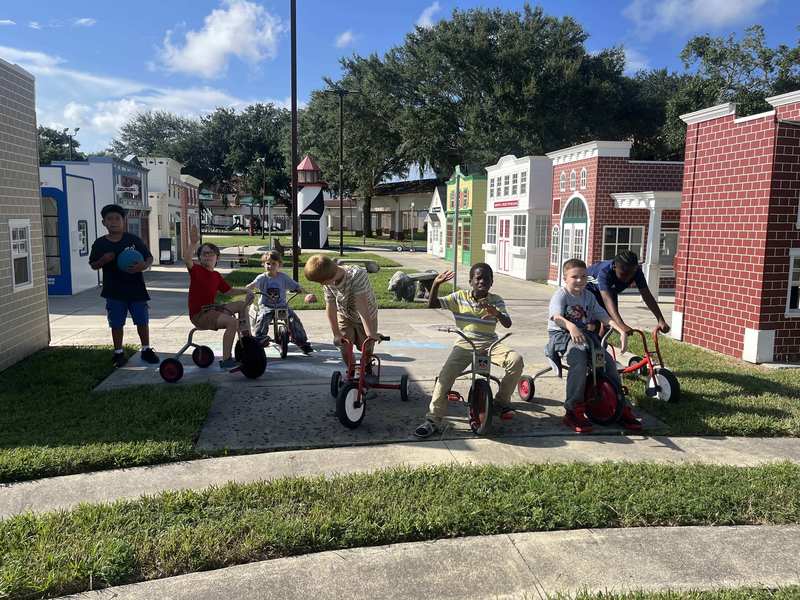 Boys riding trikes in Kids Town.