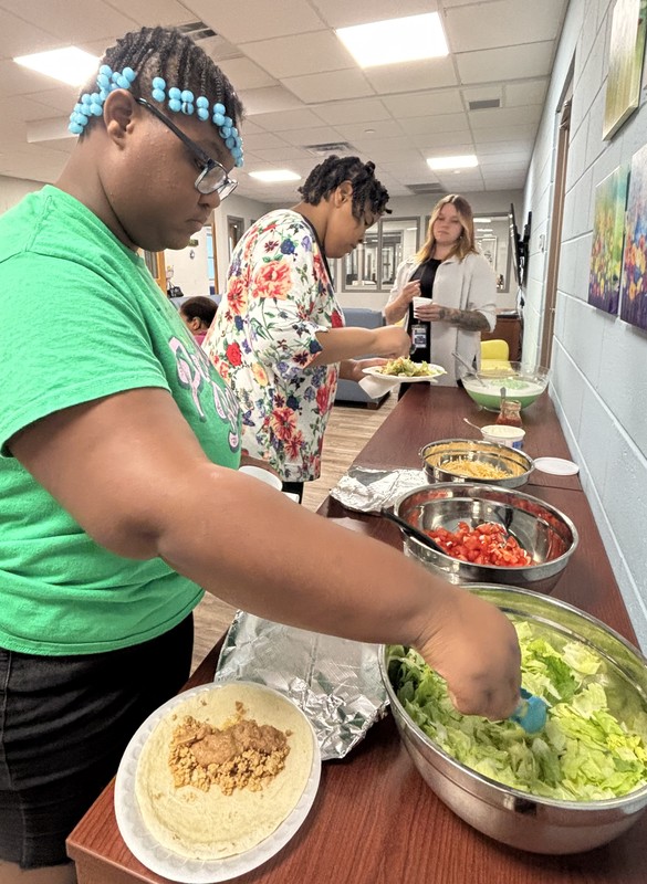 Girls making plates at a taco bar.