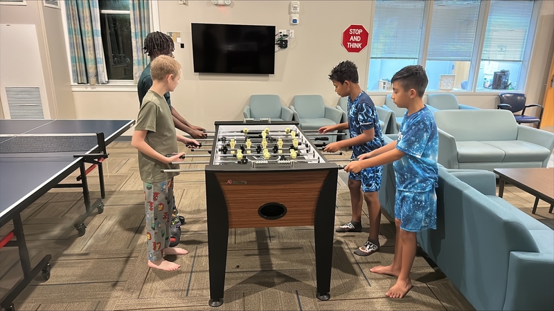 Four boys playing foosball.