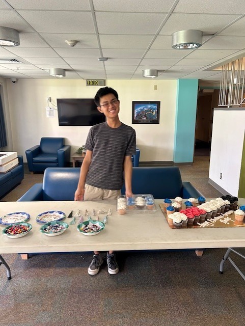 Gabe standing at the cupcake table.