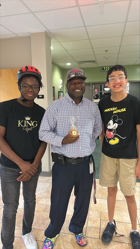 Two boys giving a candied apple to David Mack.