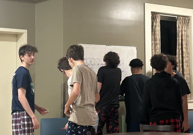 Boys writing on white board.