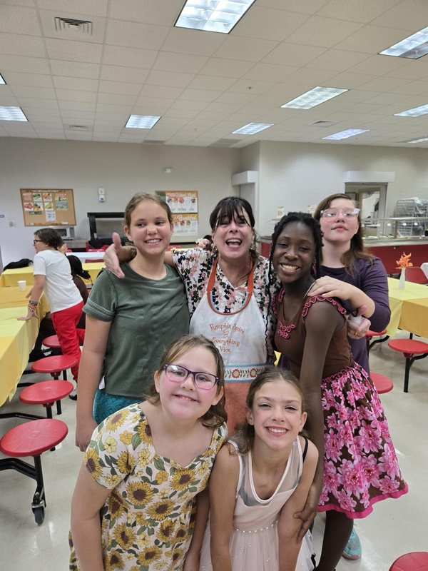 Deaf elementary girls with staff member during Thanksgiving Dinner.