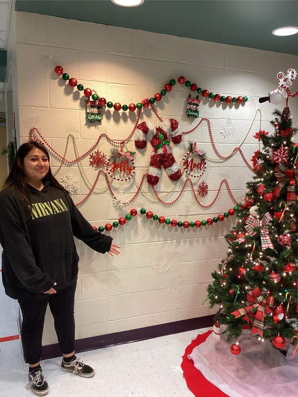 Girls standing in front of wall decorations.