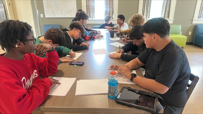 Boys sitting down and creating vision boards in Rhyne Hall