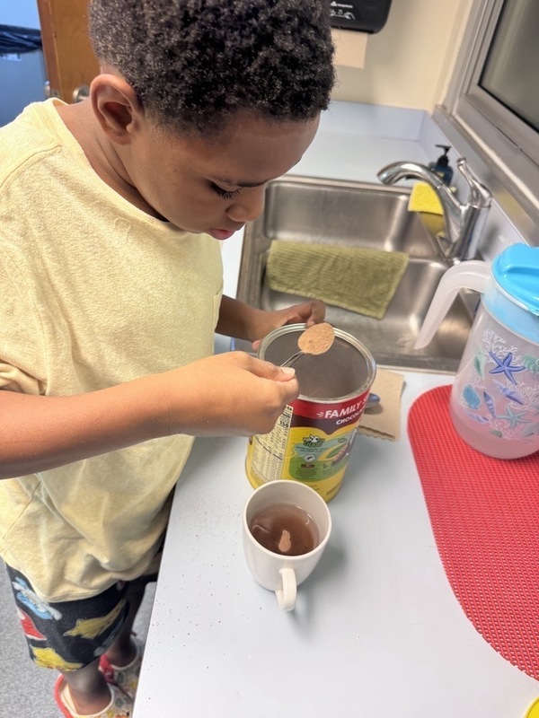 Elementary student making hot chocolate