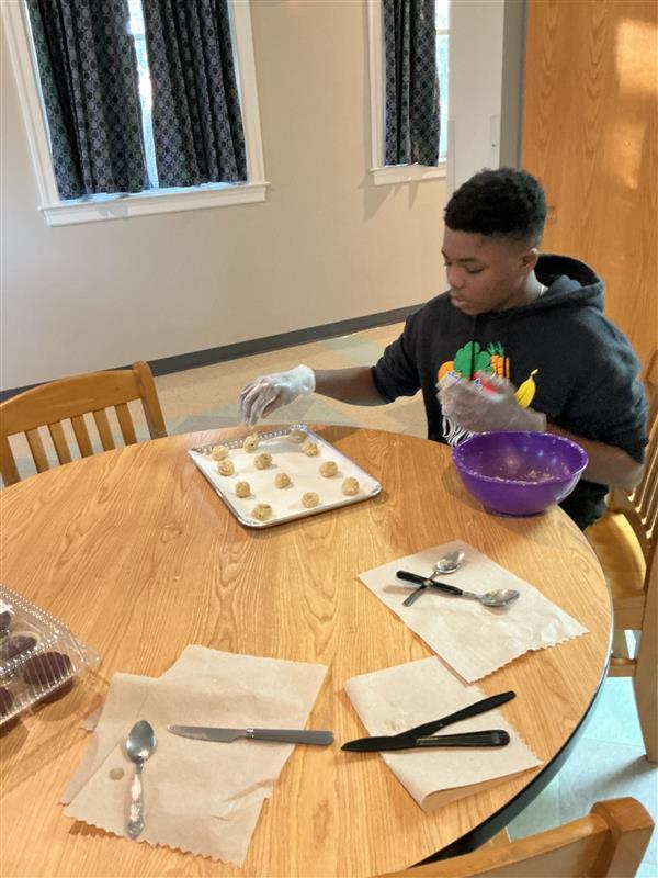Student sitting down making cookies
