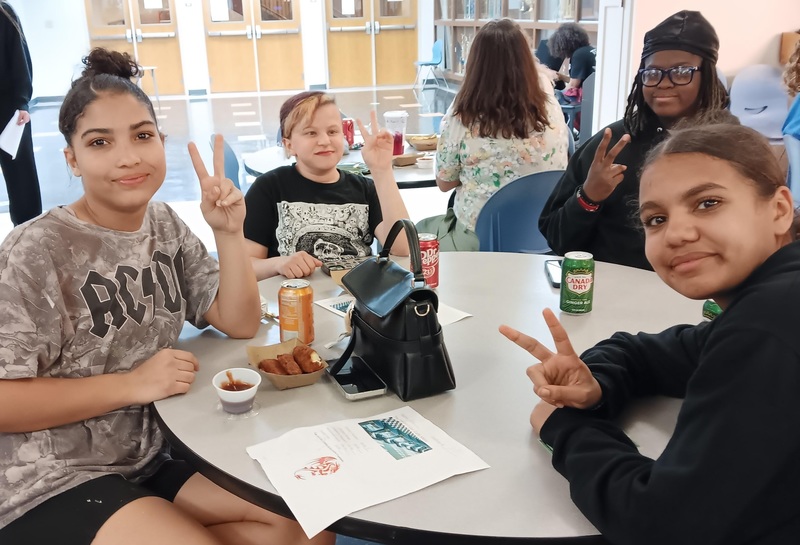 Students sitting down at table enjoying food