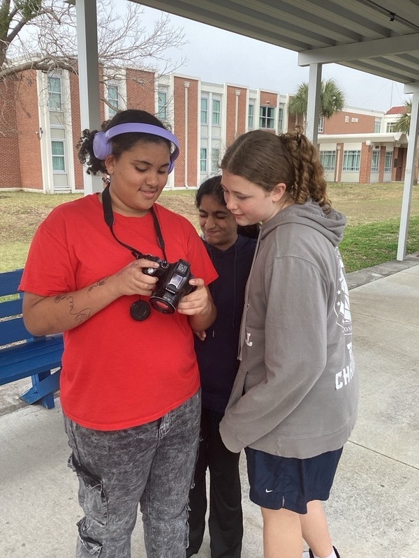 Girl showing friends a photo on her camera.