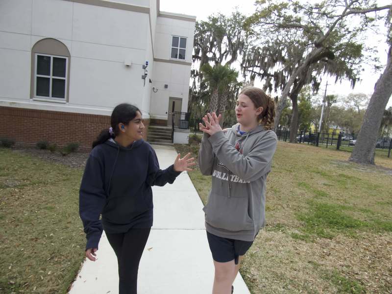 Two girls chatting as they walk from James Hall.