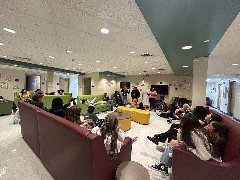 Girls sitting in their living room listening to a lesson.