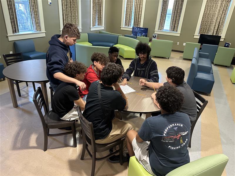 Boys sitting around a table.