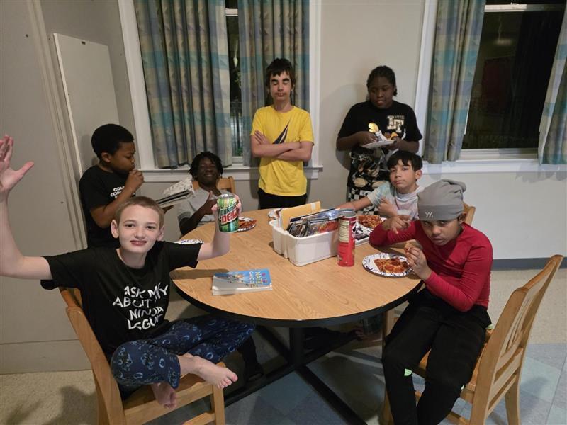 Boys sitting at table having pizza party