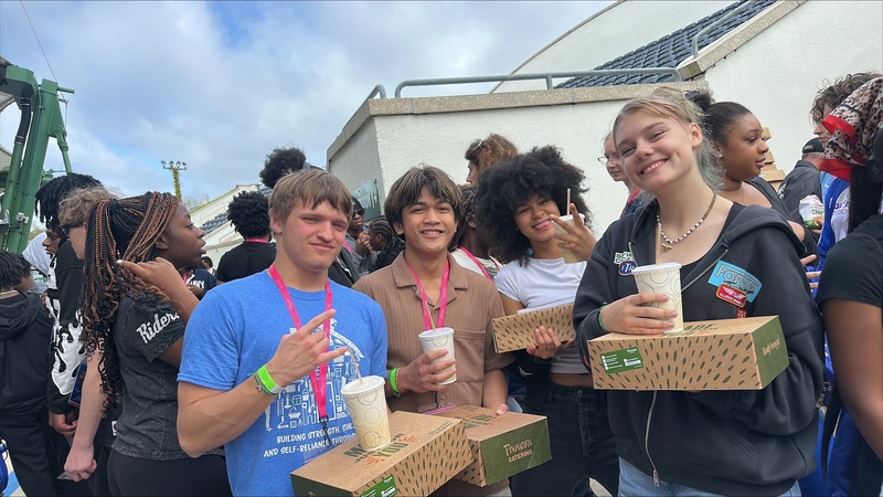 Four students smiling at Brave Summit event holding Panera