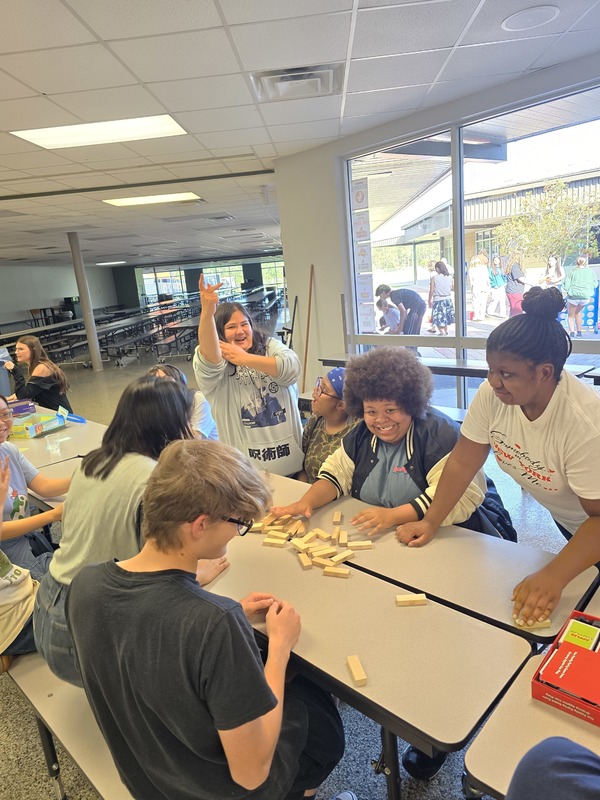 Students sitting down in Cafeteria, playing board games