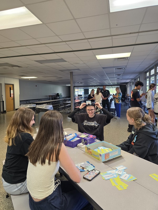 Girls sitting down in Cafeteria, playing board games