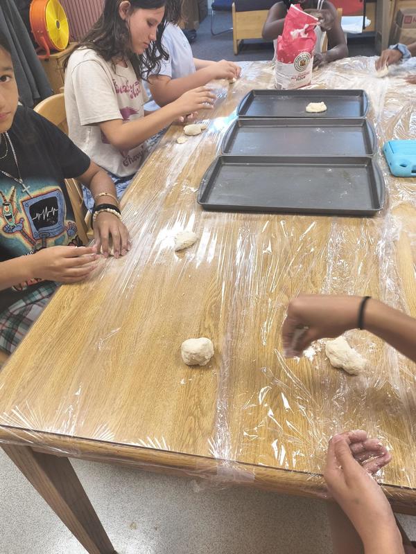 Students rolling out dough and making cookies