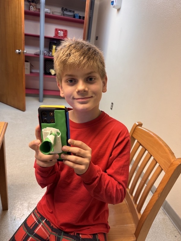 Boy student holding cellphone with foam decorations