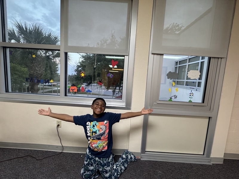 Boy posing infront of windows with foam window decorations