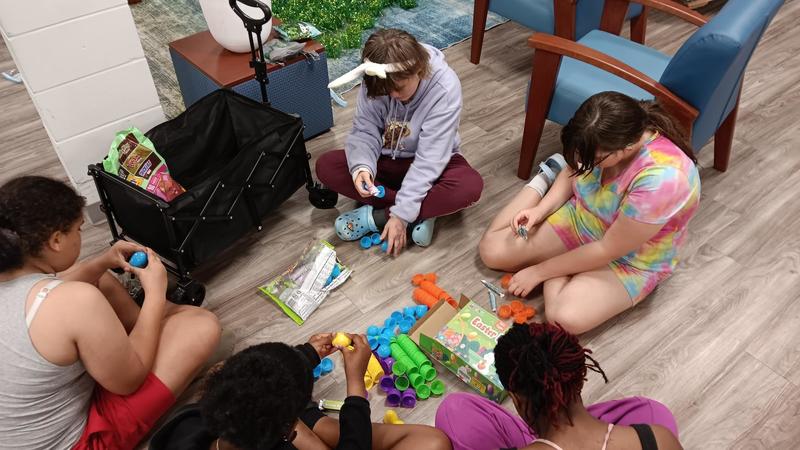 Group of girls sitting down, putting together Easter eggs